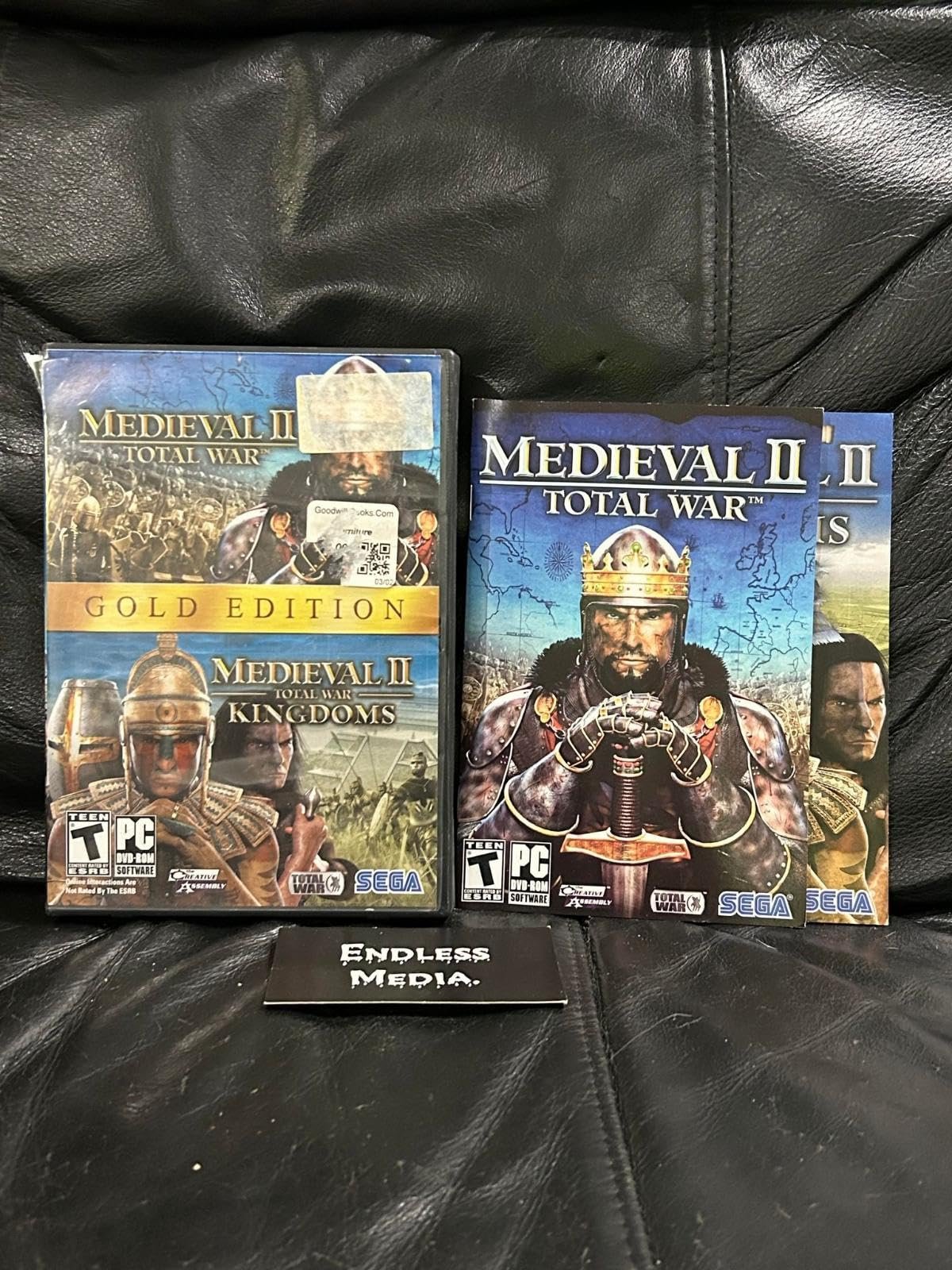 Two Medieval II: Total War PC game boxes on a leather surface